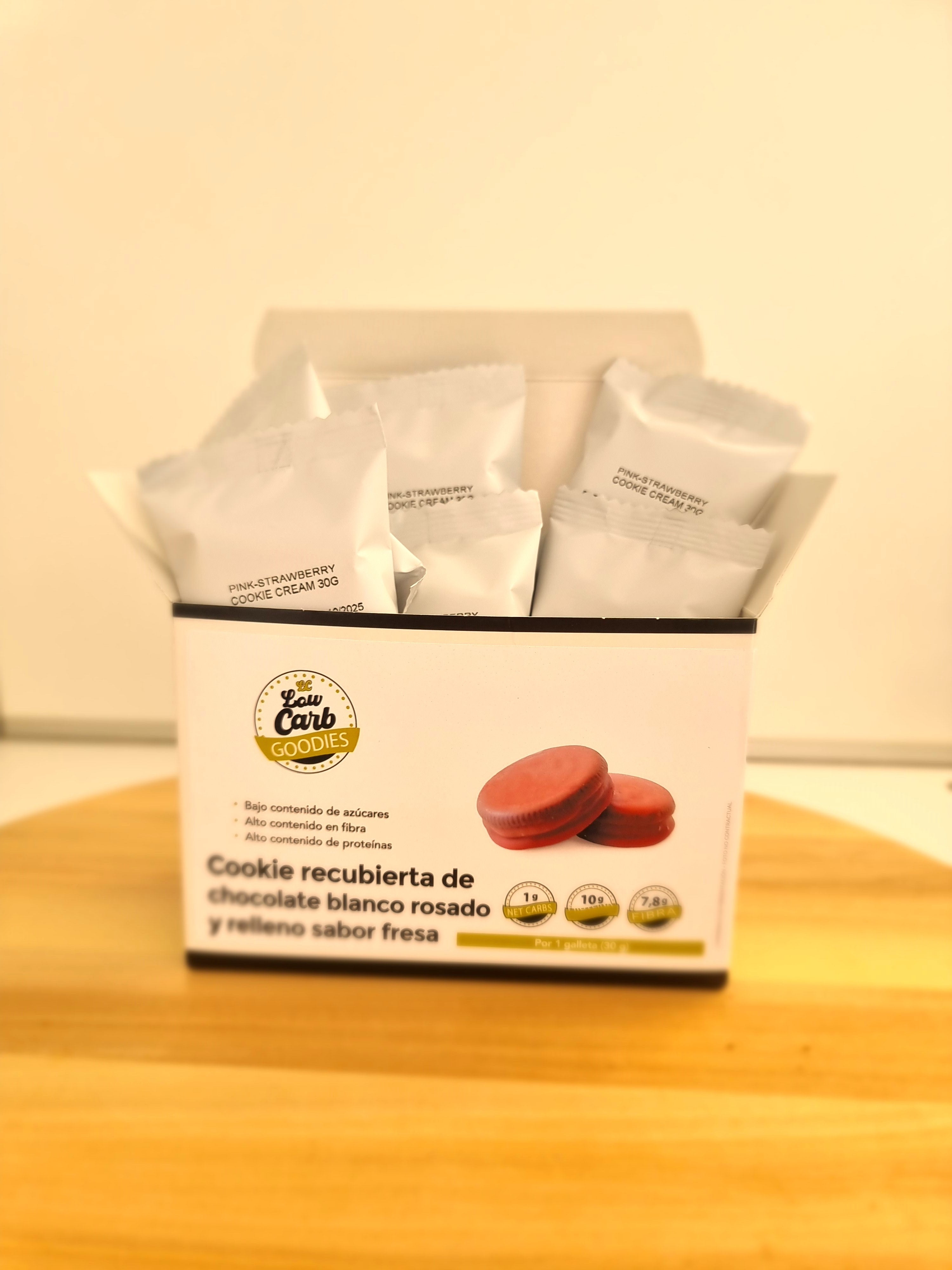 Caixa com 6 bolachas cetogénicas, recheadas com creme de morango e cobertas com chocolate rosa. 1 hidrato de carbono cada. Delícias Low-Carb